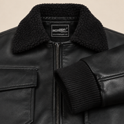 Ashford men’s black lambskin leather bomber jacket: Close-up of the black rib-knit cuff, leather and zipper.