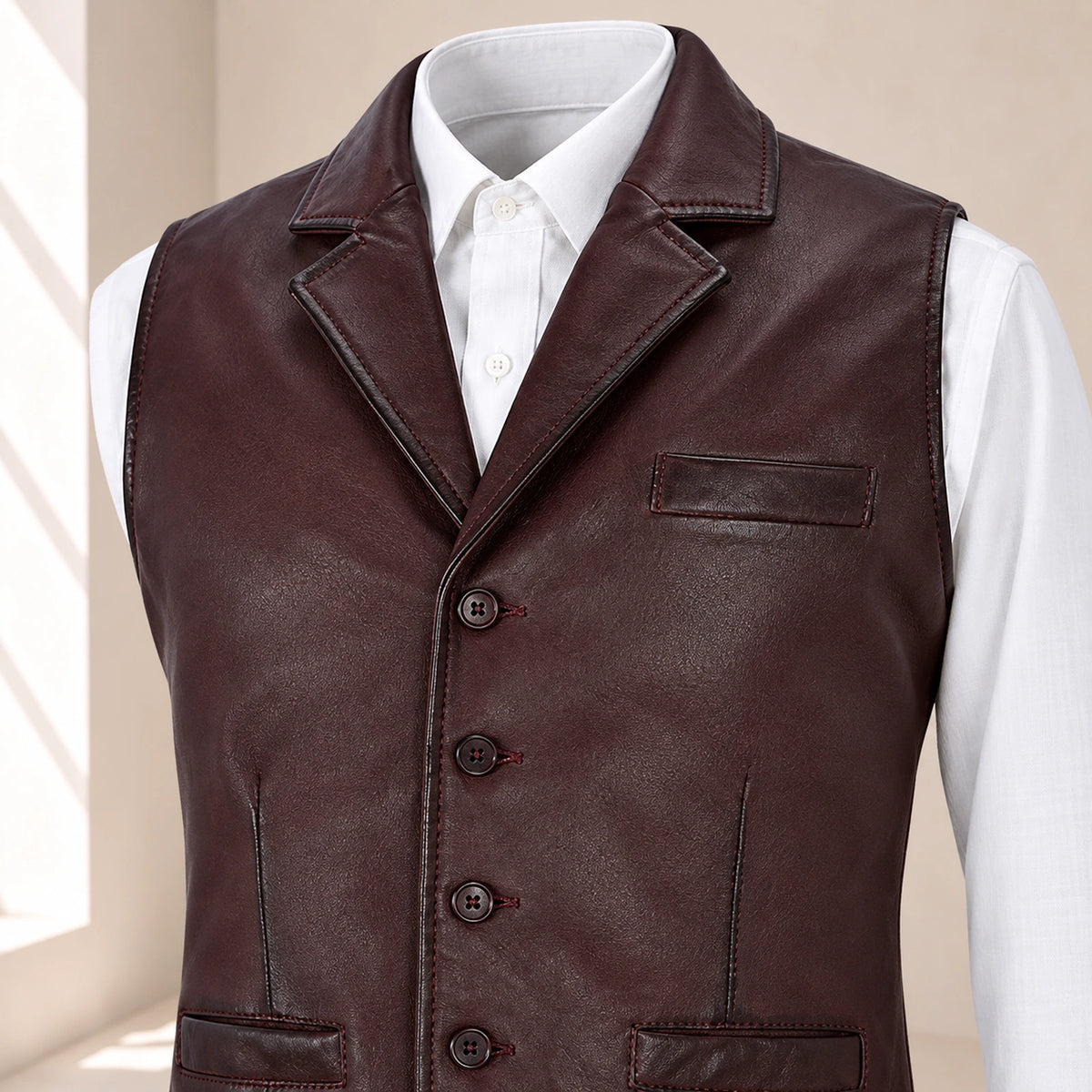 Close-up of the maroon Ellswick waistcoat's lambskin leather, notch lapel, stitching and buttons.