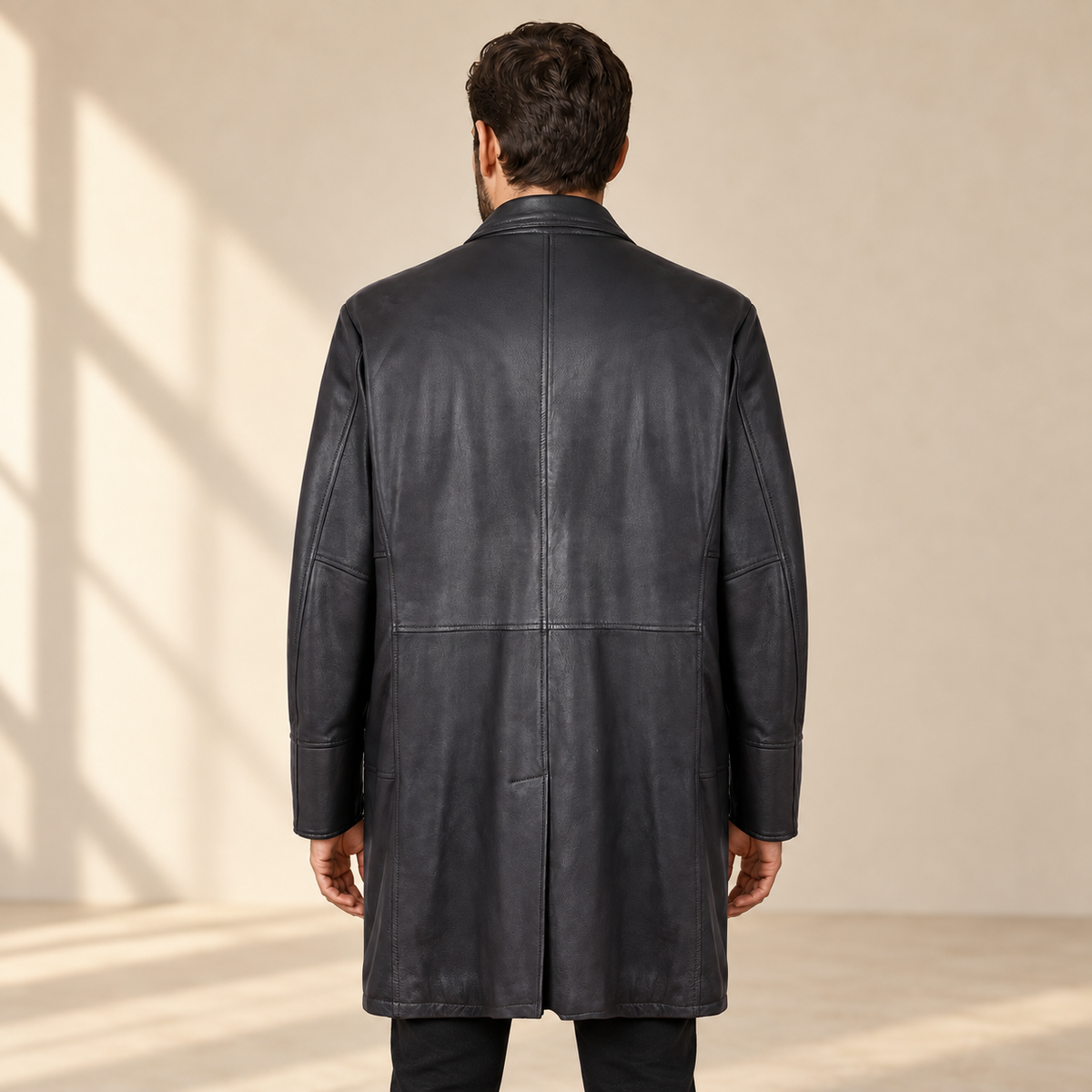 Rear view worn by a male model of the Eversham men's dark brown mid-length leather coat.