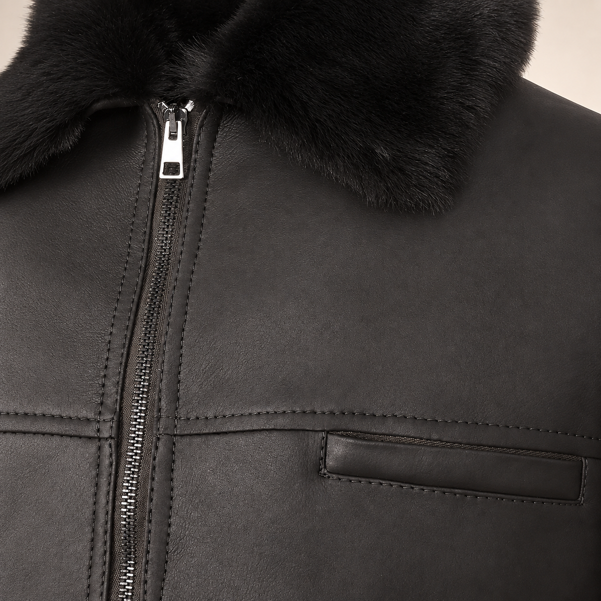 Close-up of the leather texture and construction of the Glenwick men's black shearling bomber jacket.
