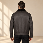 Rear view worn by a male model of the Glenwick men's black shearling bomber jacket.