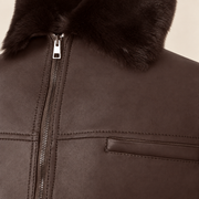 Close-up of the leather texture and construction of the Glenwick men's brown shearling bomber jacket.