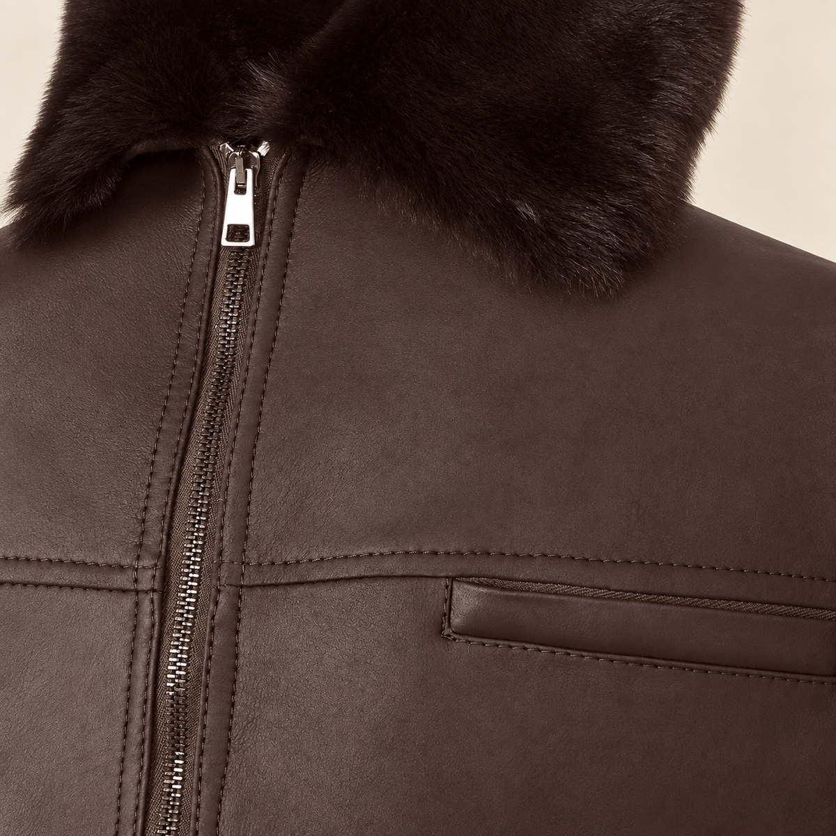 Close-up of the leather texture and construction of the Glenwick men's brown shearling bomber jacket.