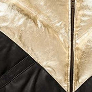 Close-up of leather texture of the MOTOGRIP black and gold lambskin leather puffer jacket, showing its black body with gold V panels.