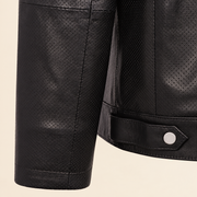 Close-up of the black perforated cuff and smooth leather hem tab with silver snap.