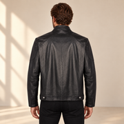 Rear model view of the Halden black jacket showing the curved yoke, center seam and hem tabs.