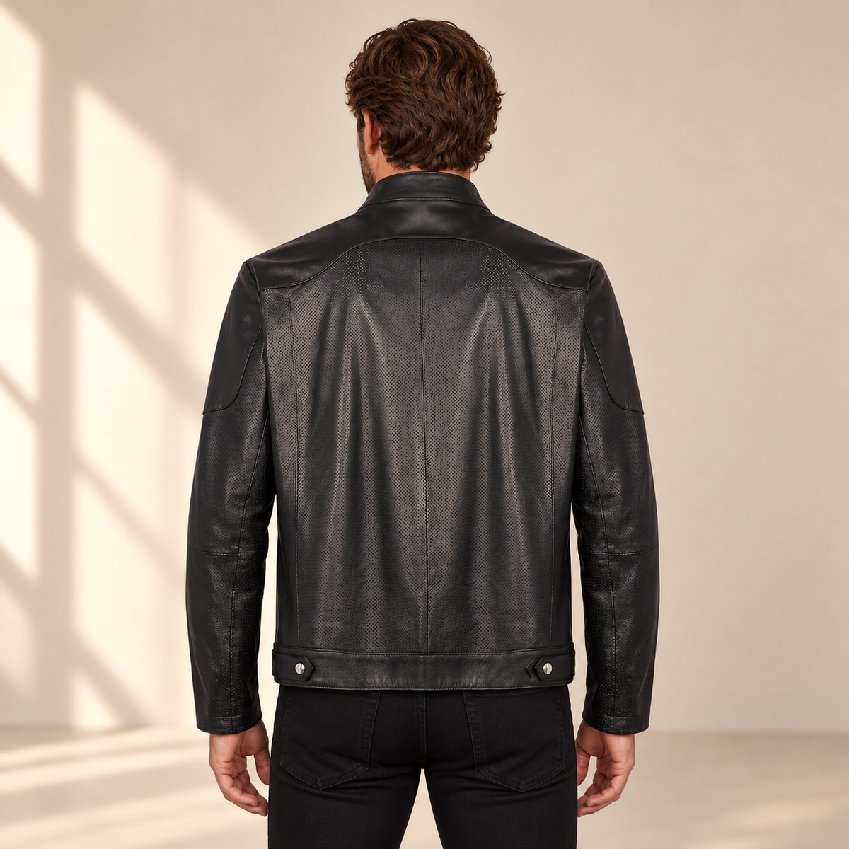 Rear model view of the Halden black jacket showing the curved yoke, center seam and hem tabs.