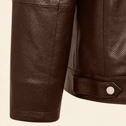 Close-up of the chocolate brown perforated cuff and smooth leather hem tab with silver snap.