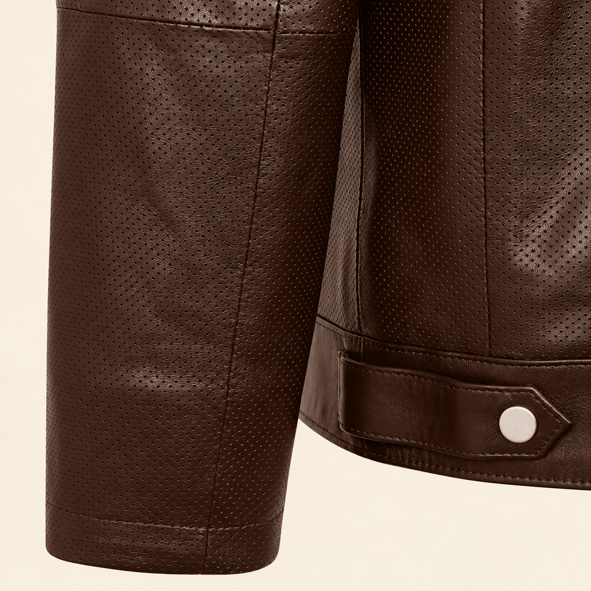 Close-up of the chocolate brown perforated cuff and smooth leather hem tab with silver snap.