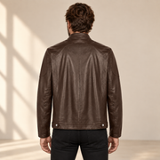 Rear model view of the Halden chocolate brown jacket showing the curved yoke, center seam and hem tabs.