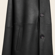 Close-up of the pocket construction of the Hawkridge men's black shearling car coat.