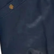 Close-up of leather texture of the MOTOGRIP red, white and navy lambskin leather puffer jacket, showing its navy body with red and white V panels.