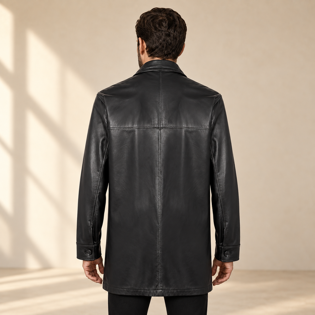 Rear view worn by a male model of the Loxley men's black leather trench coat.