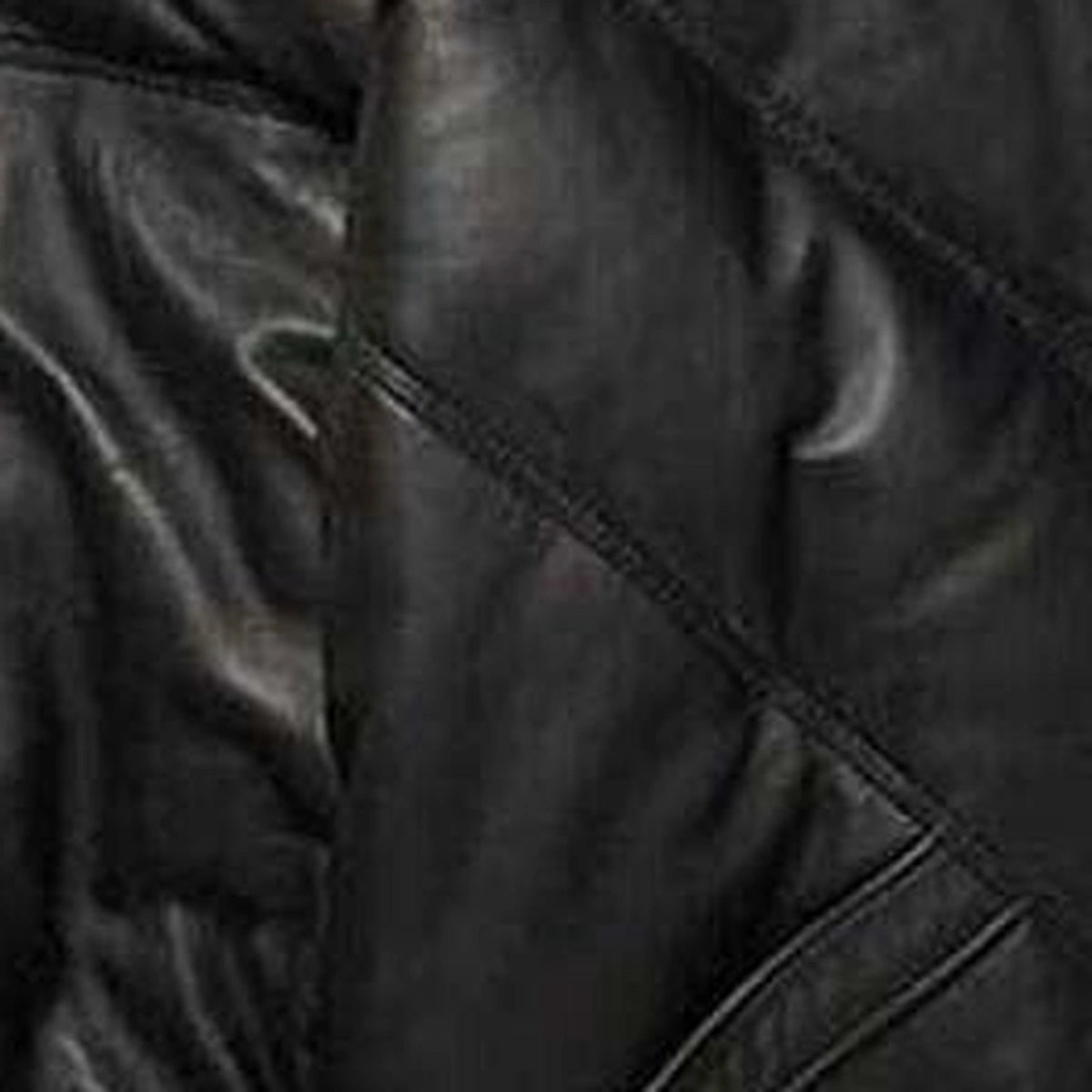 Close-up of leather texture of the MOTOGRIP black lambskin leather puffer jacket, showing its black body with tonal V stitching.