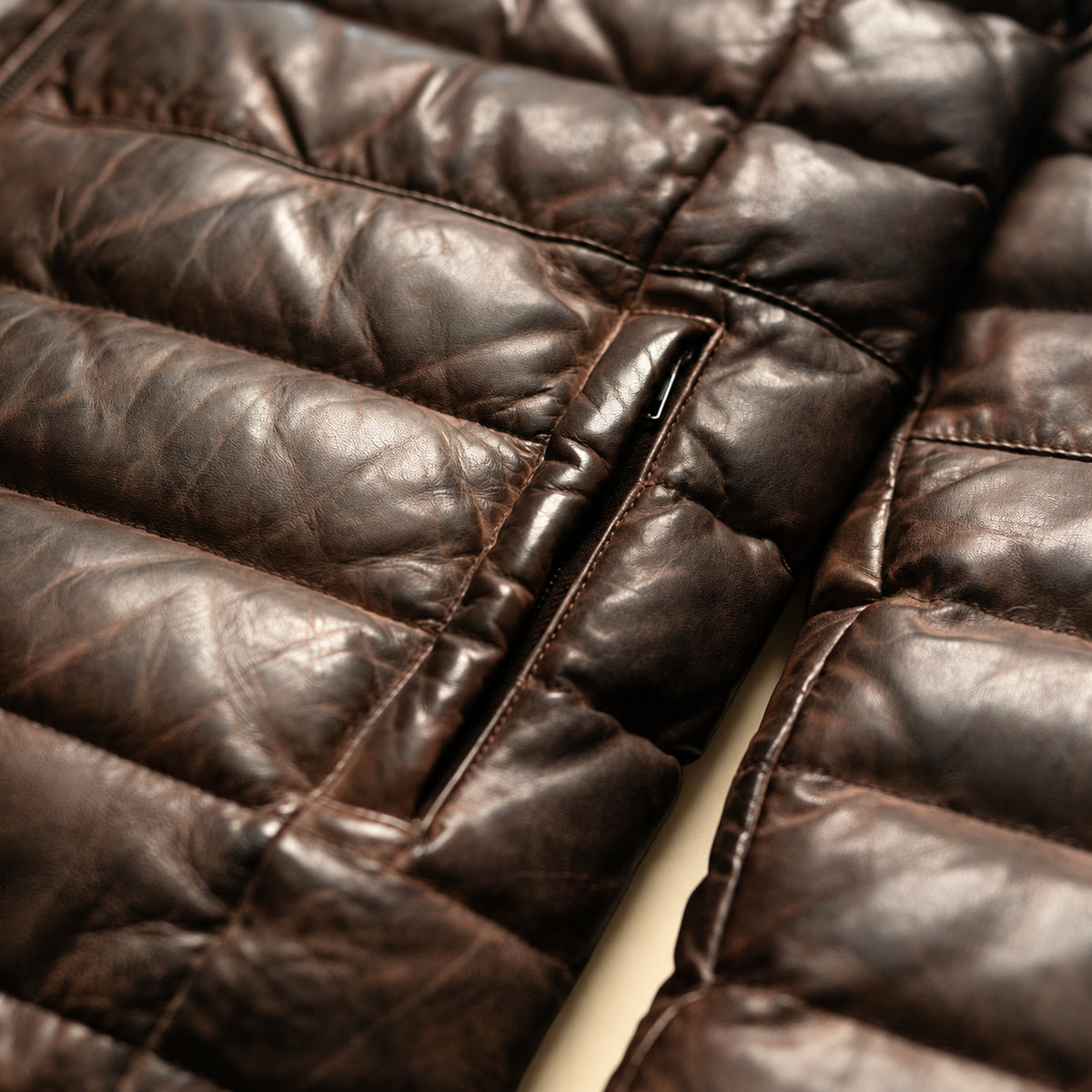 Close-up of leather grain and quilted construction of the Ridgehaven tan & brown leather down jacket.