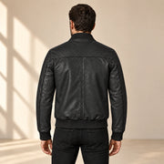 Male model wearing the black sheepskin leather MA-1 bomber jacket, back view