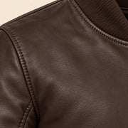 Close-up of brown bomber jacket leather grain and seam stitching