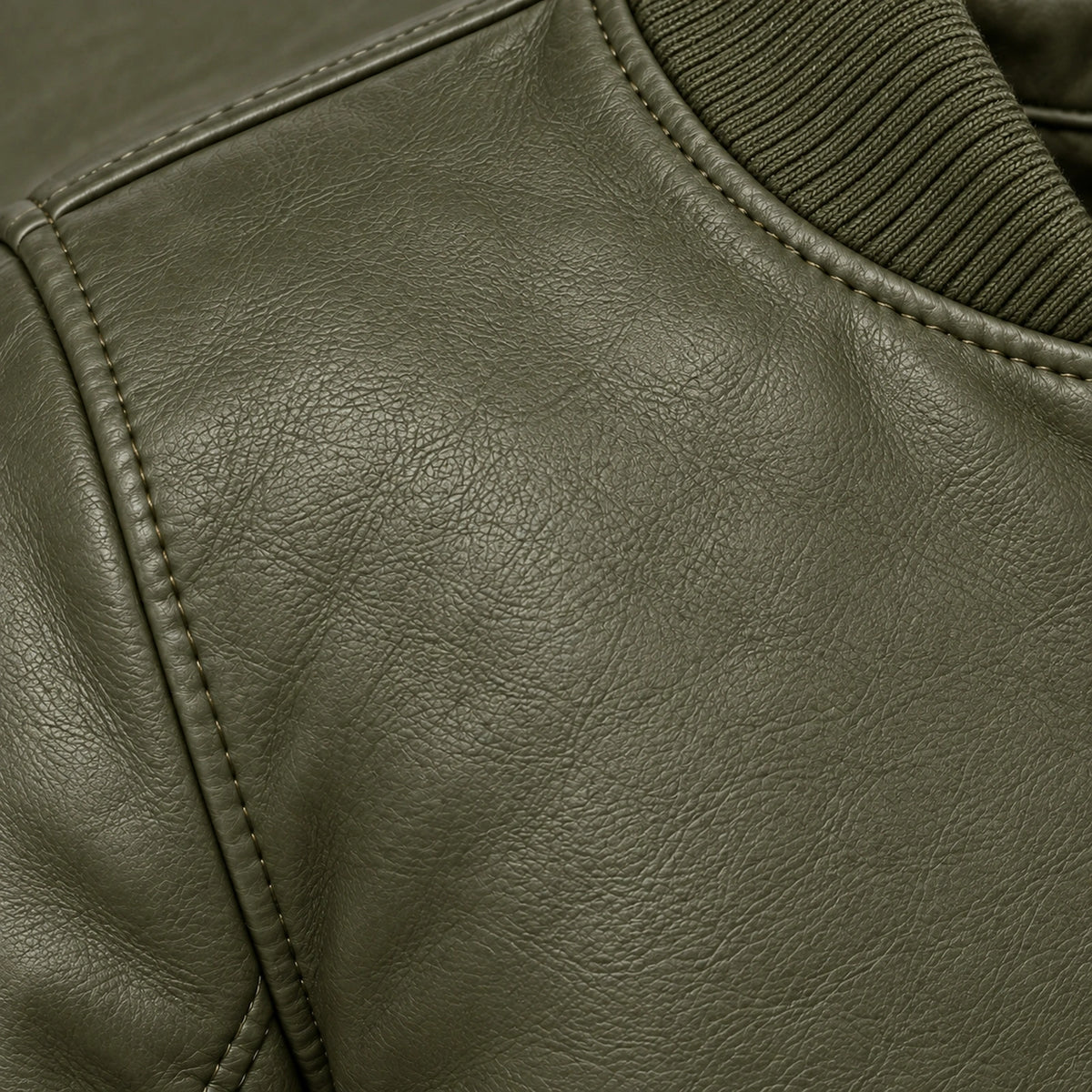 Close-up of green bomber jacket leather grain and seam stitching