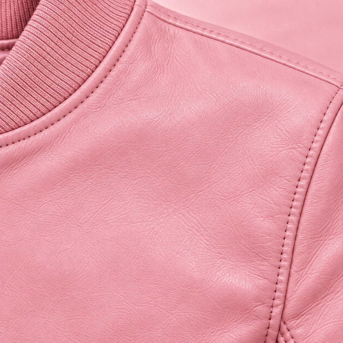 Close-up of pink bomber jacket leather grain and seam stitching